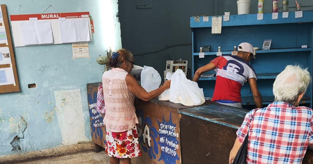 Periodista en una redaccion junto a recortes de periodico sobre critica al bloqueo interno en Cuba