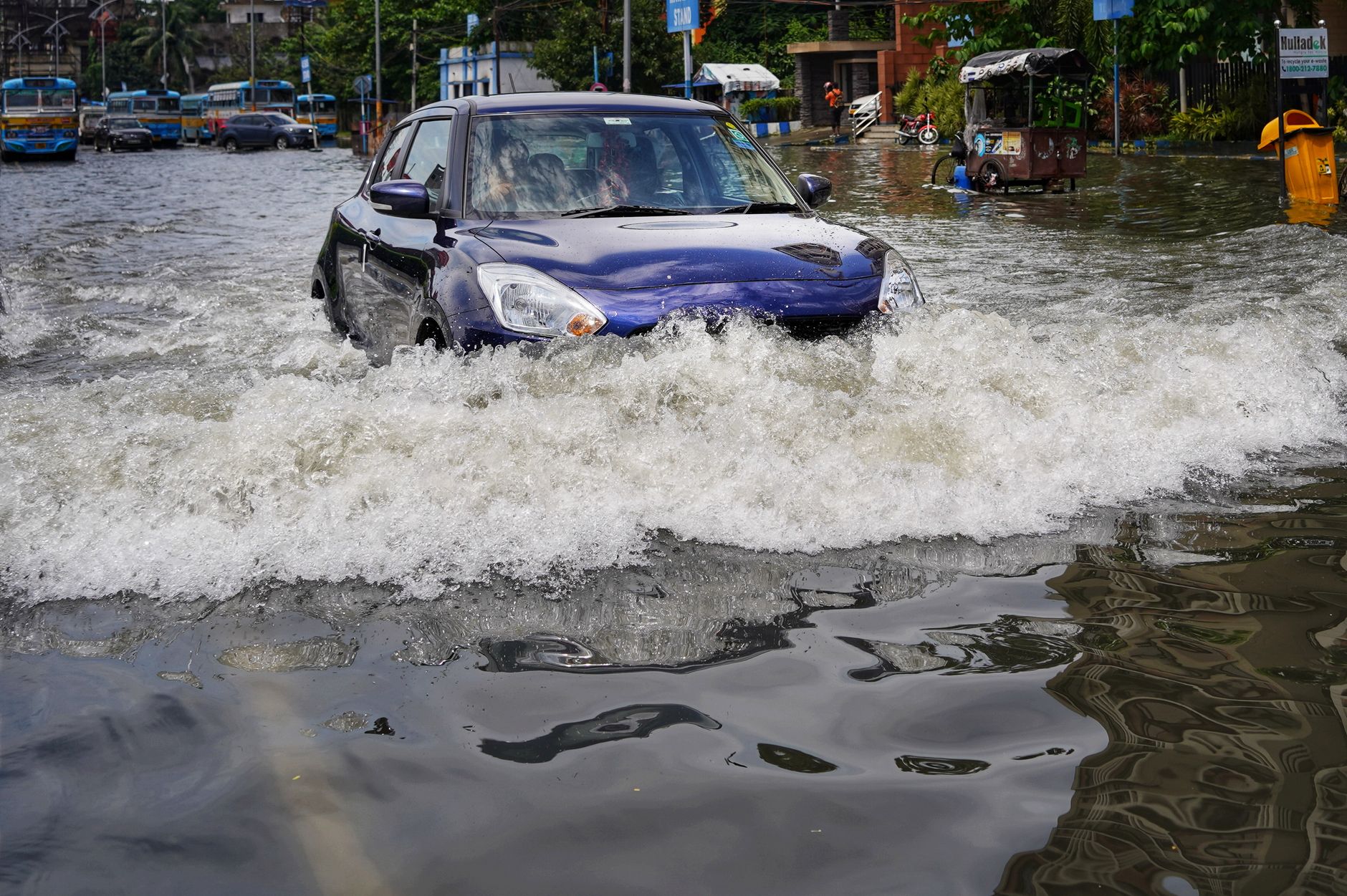 Calle inundada en Tampa con vehículos desafiando el agua.
